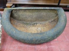 AN ANTIQUE CAST IRON TROUGH, 66 cms wide in semi-circular form