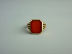 A FIFTEEN CARAT GOLD SIGNET RING with centre near square cut carnelian, 6.2 grms