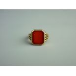 A FIFTEEN CARAT GOLD SIGNET RING with centre near square cut carnelian, 6.2 grms