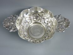 A HALLMARKED SILVER QUAICHE with inset coin base, the highly decorative two handled cup with