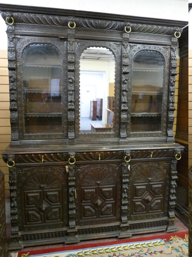 A LARGE FLEMISH STYLE THREE DOOR BOOKCASE CUPBOARD, the inverted crown over a gadrooned frieze