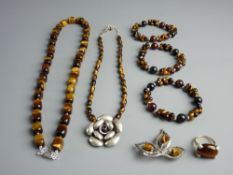 A GOOD ENSEMBLE OF TIGER'S EYE ADORNED DRESS JEWELLERY - a bead necklace, three bracelets, a