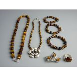 A GOOD ENSEMBLE OF TIGER'S EYE ADORNED DRESS JEWELLERY - a bead necklace, three bracelets, a