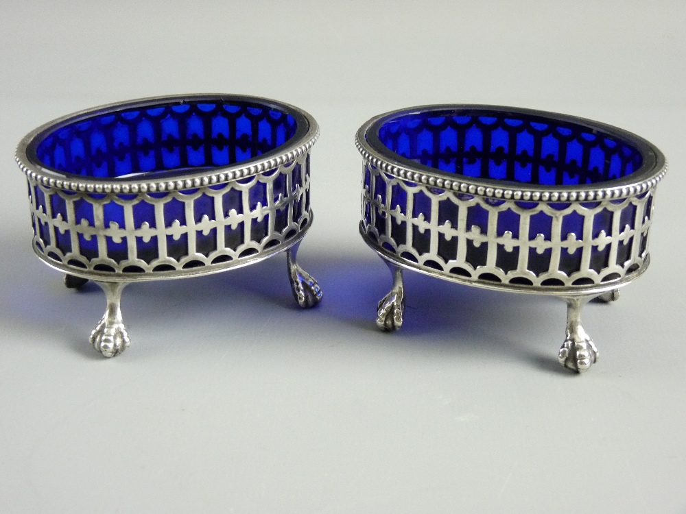 A PAIR OF OVAL SILVER SALTS with Gothic style pierced decoration on four ball and claw supports,