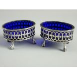 A PAIR OF OVAL SILVER SALTS with Gothic style pierced decoration on four ball and claw supports,