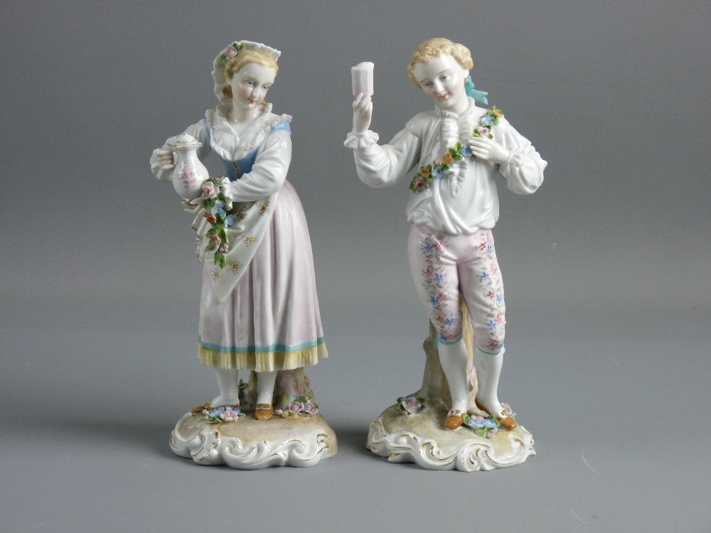 A PAIR OF GERMAN PORCELAIN FIGURES in 18th Century style dress of a young standing man with a