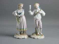 A PAIR OF GERMAN PORCELAIN FIGURES in 18th Century style dress of a young standing man with a