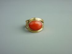 A FIFTEEN CARAT GOLD DRESS RING with oval coral cabochon, 5.5 grms