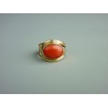 A FIFTEEN CARAT GOLD DRESS RING with oval coral cabochon, 5.5 grms