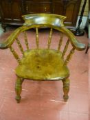 A VINTAGE SMOKER'S BOW ARMCHAIR with spindle turned arm and base supports with 'H' cross