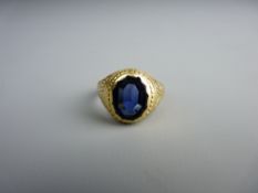 AN EIGHTEEN CARAT GOLD SIGNET RING with dark blue oval stone, 13 grms