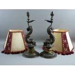 A PAIR OF EMPIRE STYLE MYTHICAL DOLPHIN TABLE LAMPS with shades, the cast metal with bronze effect