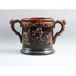A LARGE ROCKINGHAM TYPE TREACLE GLAZED LOVING CUP with coiled snake to the interior (head absent),
