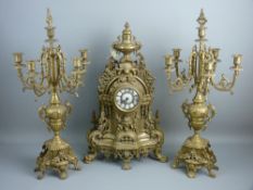 A LOUIS XVI STYLE BRASS CLOCK GARNITURE, the bell striking movement behind a brass and enamel dial