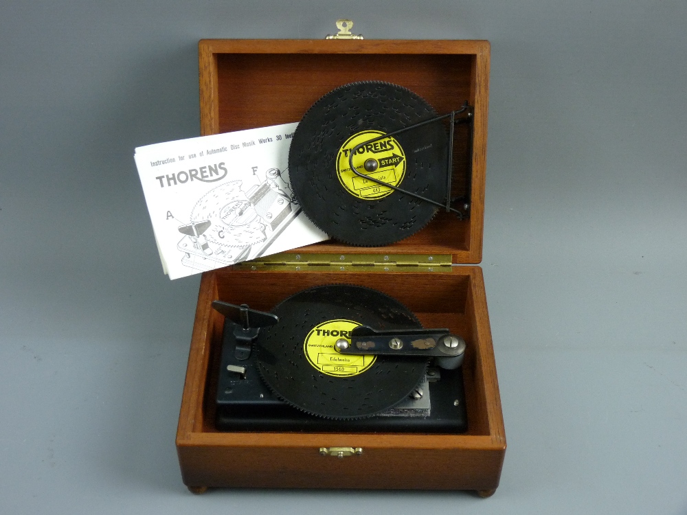 A THORENS VINTAGE MUSICAL DISC PLAYER with six pierced metal discs in a mahogany box, 19 cms wide