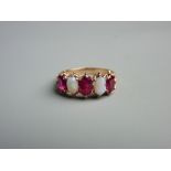 A FIFTEEN CARAT GOLD RUBY (three) & OPAL (two) DRESS RING, all oval cut stones, size 'O/P', 4.5