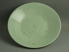 A LARGE GREEN CELADON DISHED CHARGER PLATE, 37 cms diameter