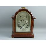 A MAHOGANY THREE TRAIN BRACKET CLOCK, the arched silvered dial set with Roman numerals, with slow/