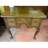 A REPRODUCTION CROSSBANDED OAK LOWBOY, the shaped rectangular top over three drawers and a lower