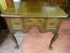 A REPRODUCTION CROSSBANDED OAK LOWBOY, the shaped rectangular top over three drawers and a lower