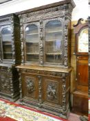 A GOOD BRETON CARVED OAK BOOKCASE CUPBOARD, the upper section with twin glazed doors and interior