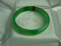 A FINELY COLOURED CIRCULAR PLAIN JADE BRACELET, 5 cms diameter