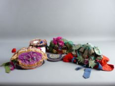 FOUR VINTAGE CHINESE BONNETS & A POUCH, all in rich embroidered colours including two in the form of