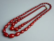 A NECKLACE OF OVAL GRADUATED AMBER COLOURED BEADS and a necklace of graduated amber coloured