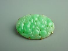 AN ORIENTAL RELIEF CARVED JADE BROOCH, oval shaped depicting fruit and flowers in unmarked yellow