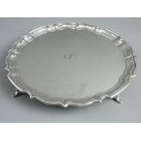 A HALLMARKED SILVER CALLING CARD TRAY with wavy border on four hoof feet, 26 cms diameter,