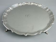 A HALLMARKED SILVER CALLING CARD TRAY with wavy border on four hoof feet, 26 cms diameter,