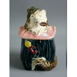 A CONTINENTAL MAJOLICA TOBACCO JAR in the form of a dog in costume with a pink ruff, 13 cms high,