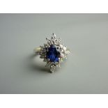 AN EIGHTEEN CARAT GOLD TANZANITE & DIAMOND DRESS RING having a centre oval blue stone with