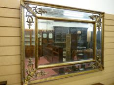 A REPRODUCTION REGENCY STYLE PIER MIRROR, the bevelled edge glass set in a double frame with pierced