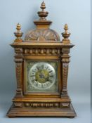 A WALNUT CASED ARCHITECTURAL STYLE MANTEL CLOCK, the silvered dial set with Roman numerals with