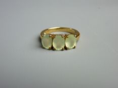 A NINE CARAT GOLD DRESS RING with three oval peridots, size 'N', 4 grms