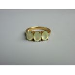 A NINE CARAT GOLD DRESS RING with three oval peridots, size 'N', 4 grms