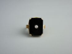 A FIFTEEN CARAT GOLD OBLONG BLACK AGATE RING with tiny centre diamond, 6.3 grms