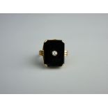 A FIFTEEN CARAT GOLD OBLONG BLACK AGATE RING with tiny centre diamond, 6.3 grms
