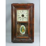 A WALNUT CASED AMERICAN WALL CLOCK by Waterbury Clock Co, the dial set with Roman numerals and