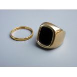 AN UNMARKED GOLD SIGNET RING with a dark agate stone, 6.2 grms gross and a twenty two carat gold