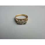 A NINE CARAT GOLD DRESS RING of three small diamonds in a split shank, 3 grms gross