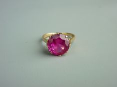 AN UNMARKED GOLD DRESS RING with attractive round cut pink stone in an attractive diamond