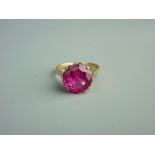 AN UNMARKED GOLD DRESS RING with attractive round cut pink stone in an attractive diamond