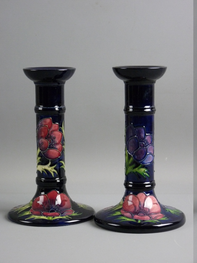 A PAIR OF MOORCROFT ANEMONE CANDLESTICKS decorated on a cobalt blue ground, impressed factory