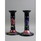 A PAIR OF MOORCROFT ANEMONE CANDLESTICKS decorated on a cobalt blue ground, impressed factory