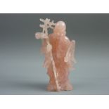 A CARVED ROSE QUARTZ FIGURE of a Chinese Immortal, the bearded standing figure holding a staff, 13