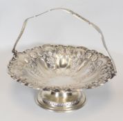 A SILVER BRIDE-STYLE BASKET decorated in good floral and scrolling repousse work and raised over a