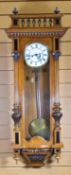 AN ANTIQUE VIENNA-STYLE WALL CLOCK with white enamel dial bearing Roman numerals, within a carved