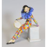 RARE WADE FIGURE OF A HARLEQUIN GIRL perched on a plinth with tambourine and wearing a blue